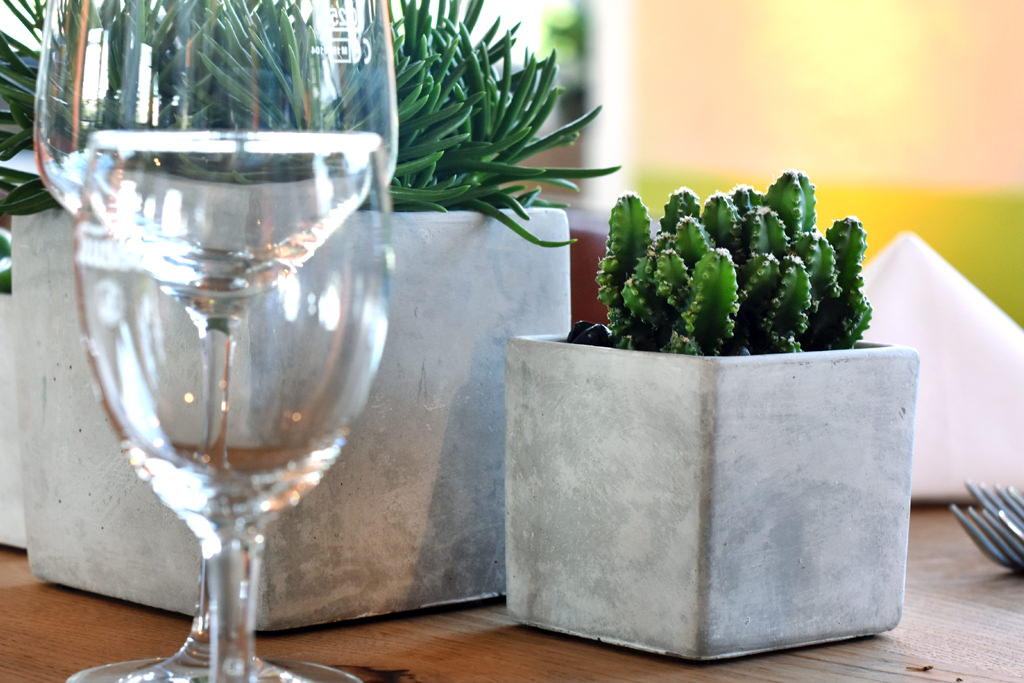 firmenevent_dekoration_industrial_look_orange_betonvase_sukkulente_mieten