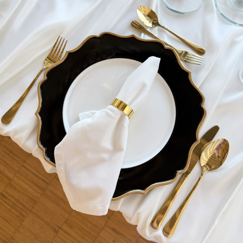 Platzteller_Kunststoff_rund_weiss_schwarz_Goldrand_Wellenrand_33cm_Besteck_gold_glänzend_mieten