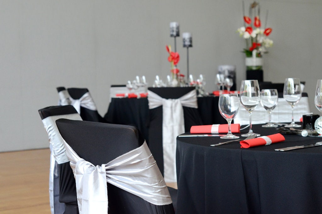 Dekoration Firmenveranstaltung schwarze Tischdecken mieten rote Akzente mit Blumen Rauers Festhalle Neckarsulm 2