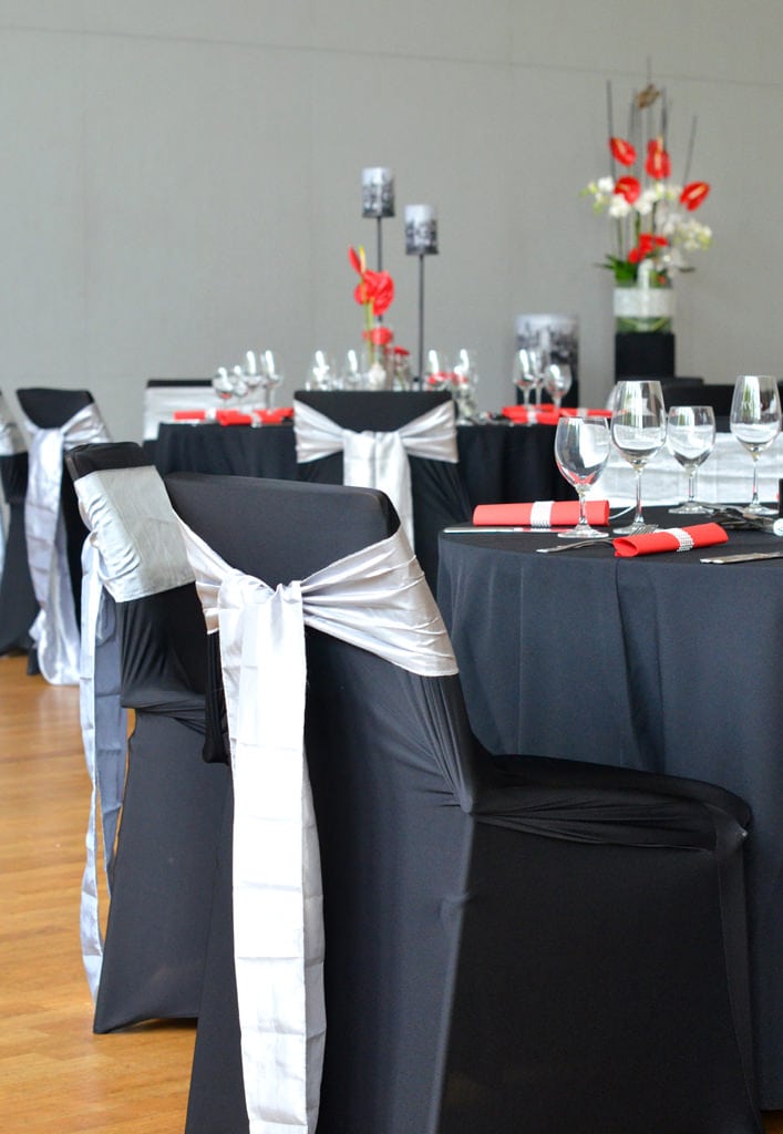 Dekoration Firmenveranstaltung schwarze Tischdecken mieten rote Akzente mit Blumen Rauers Festhalle Neckarsulm 1