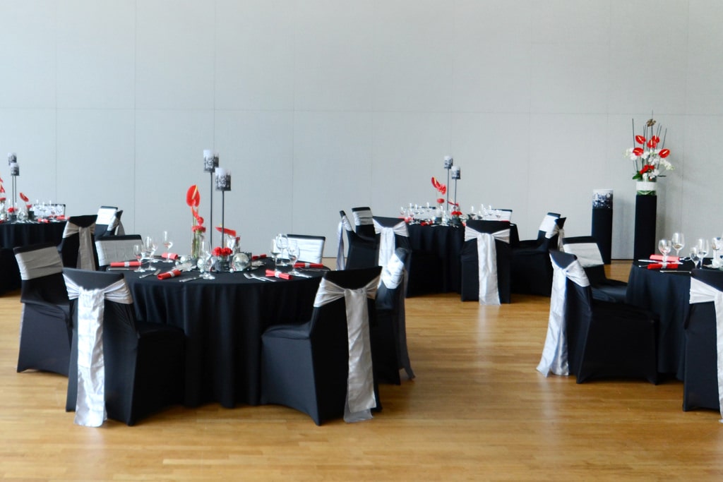 Dekoration Firmenveranstaltung schwarze Tischdecken mieten rote Akzente mit Blumen Rauers Festhalle Neckarsulm 9