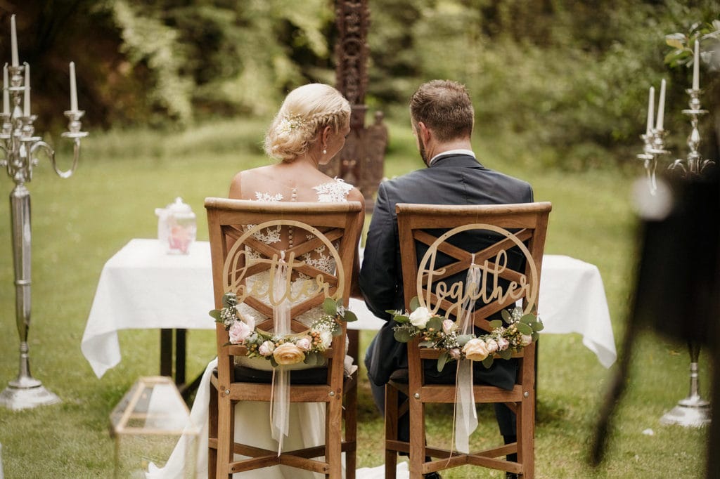 Dekoration_Hochzeit_Heidersbacher_muehle_FreieTrauung_Laterne_gold_Blumen_Baumstamm_rustikal_Wiese
