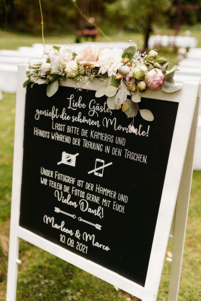 Dekoration_Hochzeit_Heidersbacher_muehle_FreieTrauung_Willkommenschild_Tafel_Beschriftet_Blumen_girlande