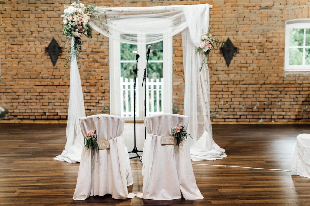 Dekoration_Hochzeit_Schloss_Assumstadt_Freie_Trauung_Traubogen_Stuehle_Brautpaar_Tuch_Gesteck_Blumen_edel_Rosen_altrosa_eukalyptus
