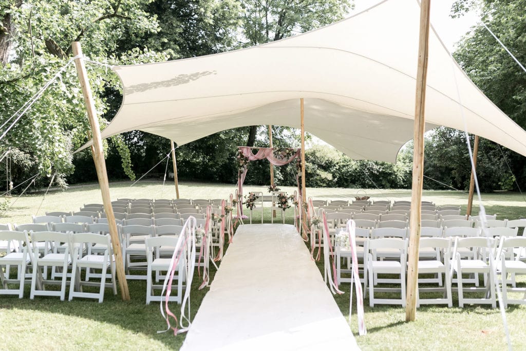 Dekoration_Hochzeit_Schlosshotel_Friedrichsruhe_Freie_Trauung_Traubogen_Birke_Blumen_Tuch_Traustuehle_Klappstuehle_weiss_Teppich
