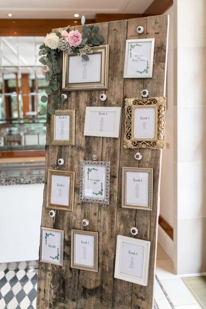 Dekoration_Hochzeit_Schlosshotel_Friedrichsruhe_Sitzplan_Tafel_Tuer_Bilderrahmen_Blumen_Mieten