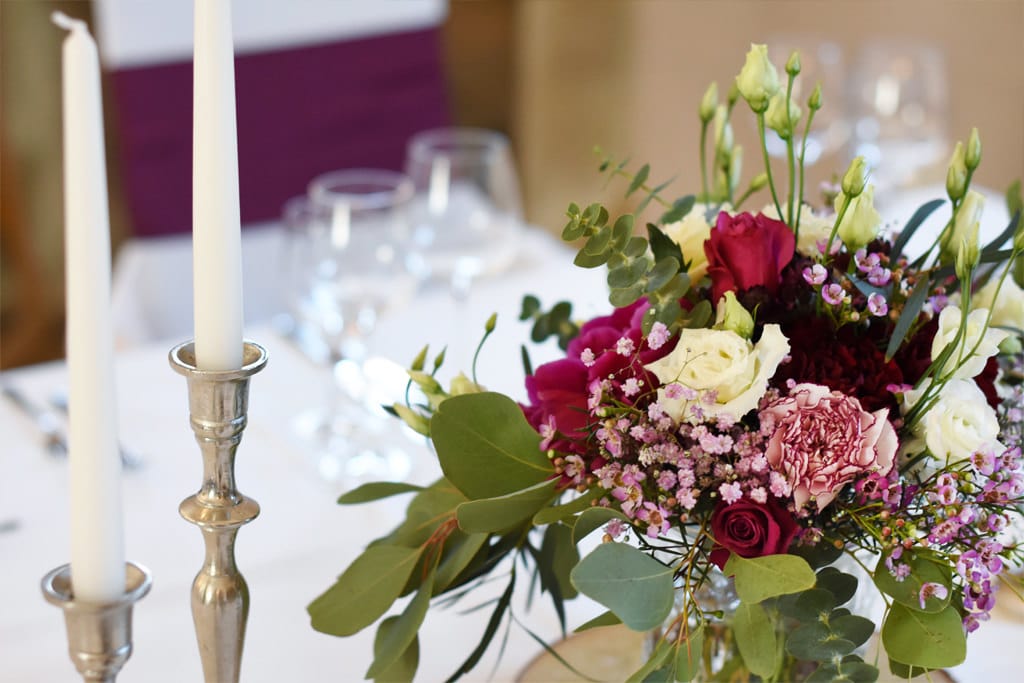 hochzeit_dekoration_burg_stettenfels_herzogsaal_tischdeko_Kerzenstaender_silber_blumen_beere_aubergine_eukalyptus