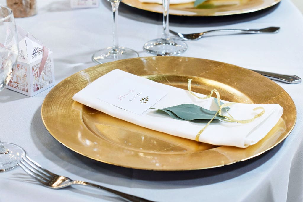 Ein gedeckter Tisch mit goldenen Tellern und Servietten.