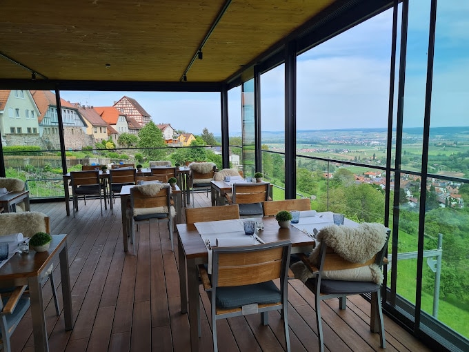 Eine malerische Restaurantterrasse des Landhaus Hohly mit Panoramablick auf die Landschaft und traditionelle Architektur.