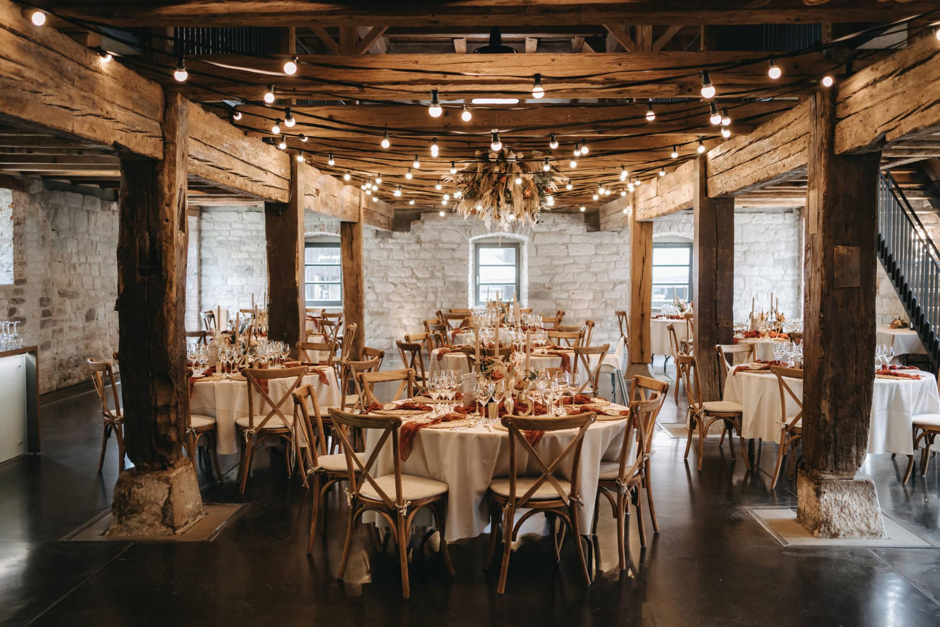 Eleganter Festsaal im rustikalen Stil für eine Veranstaltung im Weingut Steinbachhof in Vaihingen, mit Holzbalken und warmer Beleuchtung.