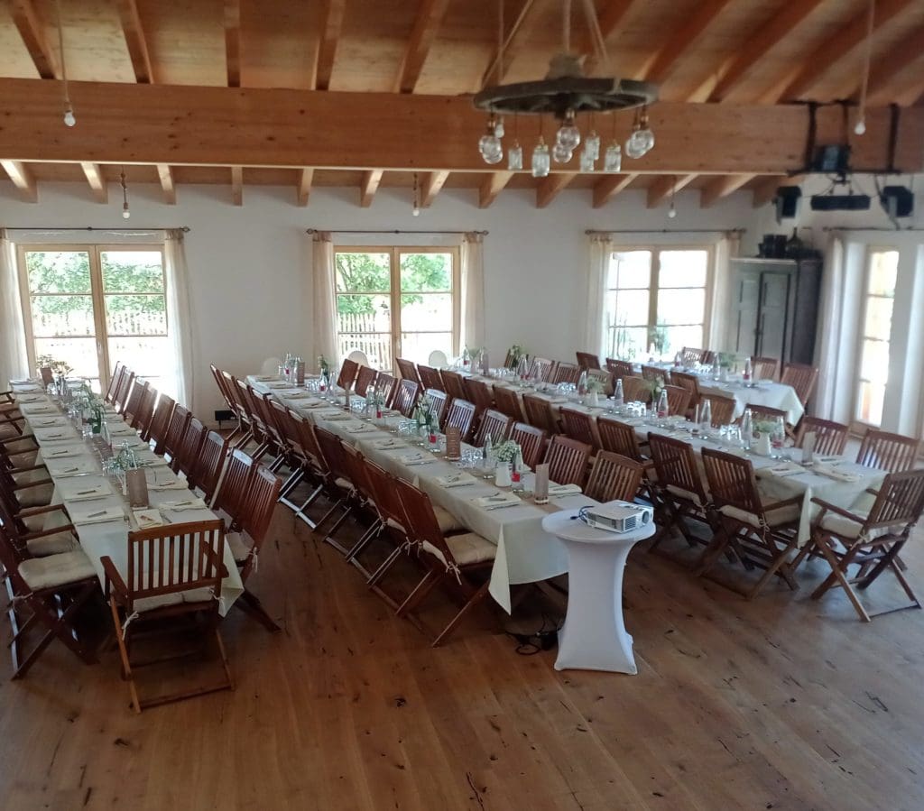 Ein eingerichteter Speisesaal in Murrhardt mit Holztischen, Stühlen und eleganten Tischdekorationen, bereit für eine Veranstaltung.