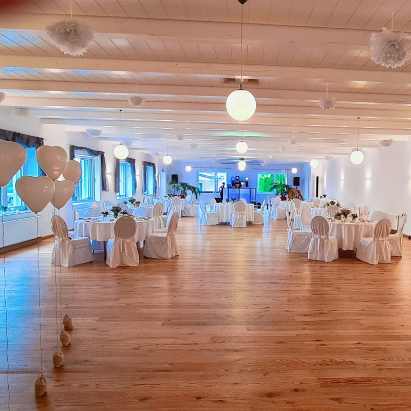 Gut beleuchteter, für die Veranstaltung eingerichteter Bankettsaal mit Tischen, Stühlen und dekorativen Luftballons – finden Sie ganz einfach Veranstaltungsorte für Ihre nächste große Feier.
