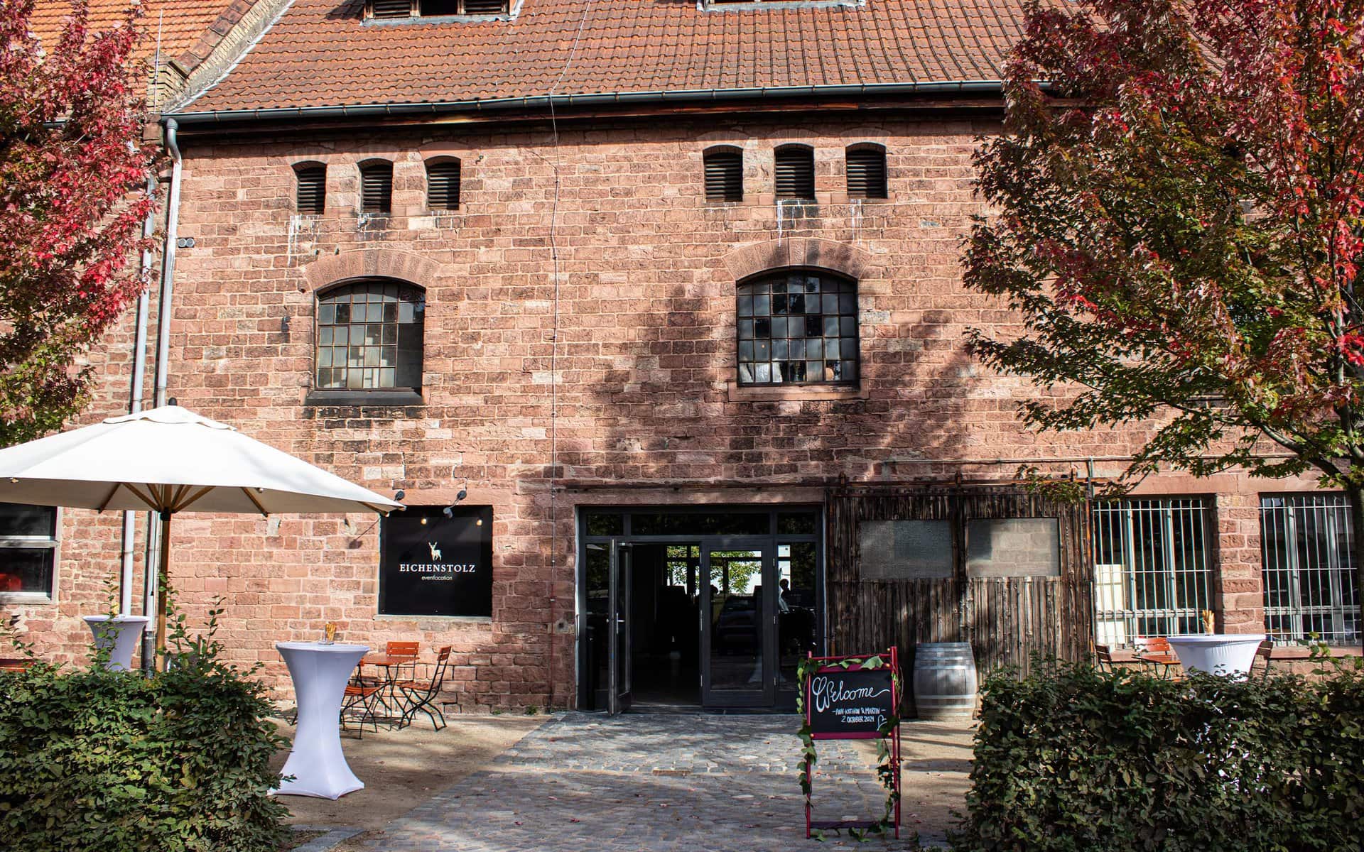 Backsteingebäude mit Bogenfenstern, Terrassenbereich und Beschilderung als Hinweis auf ein Restaurant oder Café in Ladenburg.