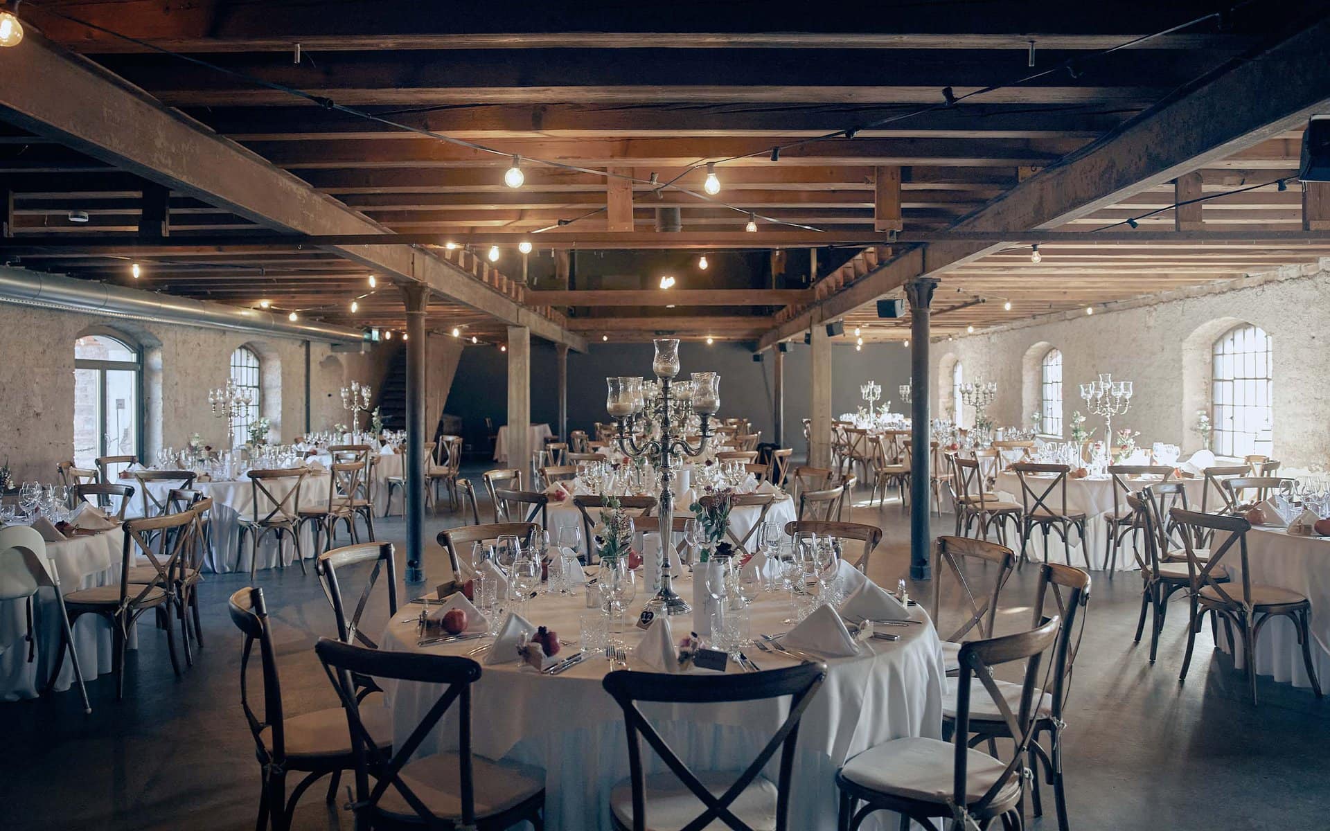 Elegantes Festsaal-Set für eine Veranstaltung im Eichenstolz in Ladenburg mit dekorierten Tischen und Holzbalken.