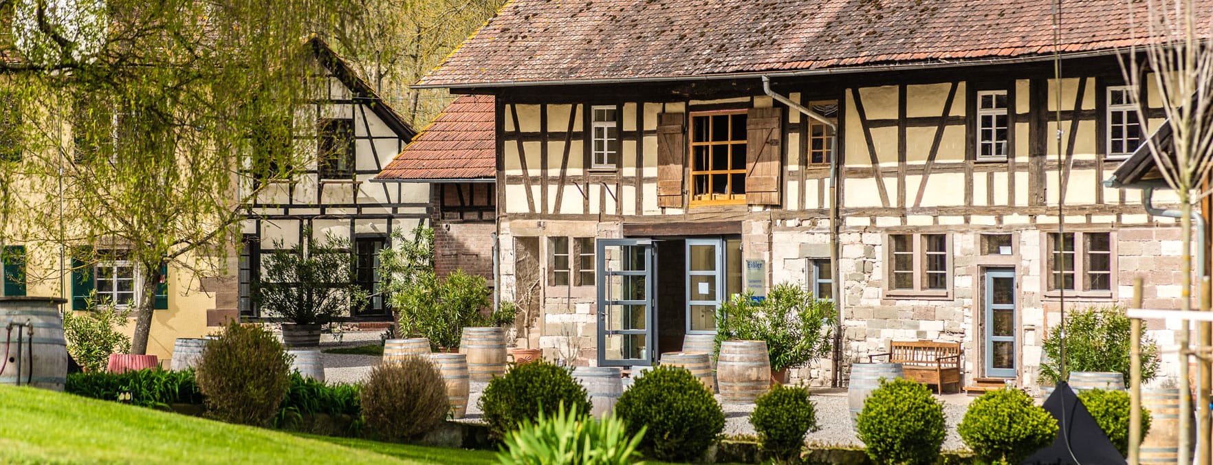 Traditionelle Fachwerkhäuser in ländlicher Umgebung mit viel Grün beim Weingut Steinbachhof, Vaihingen.